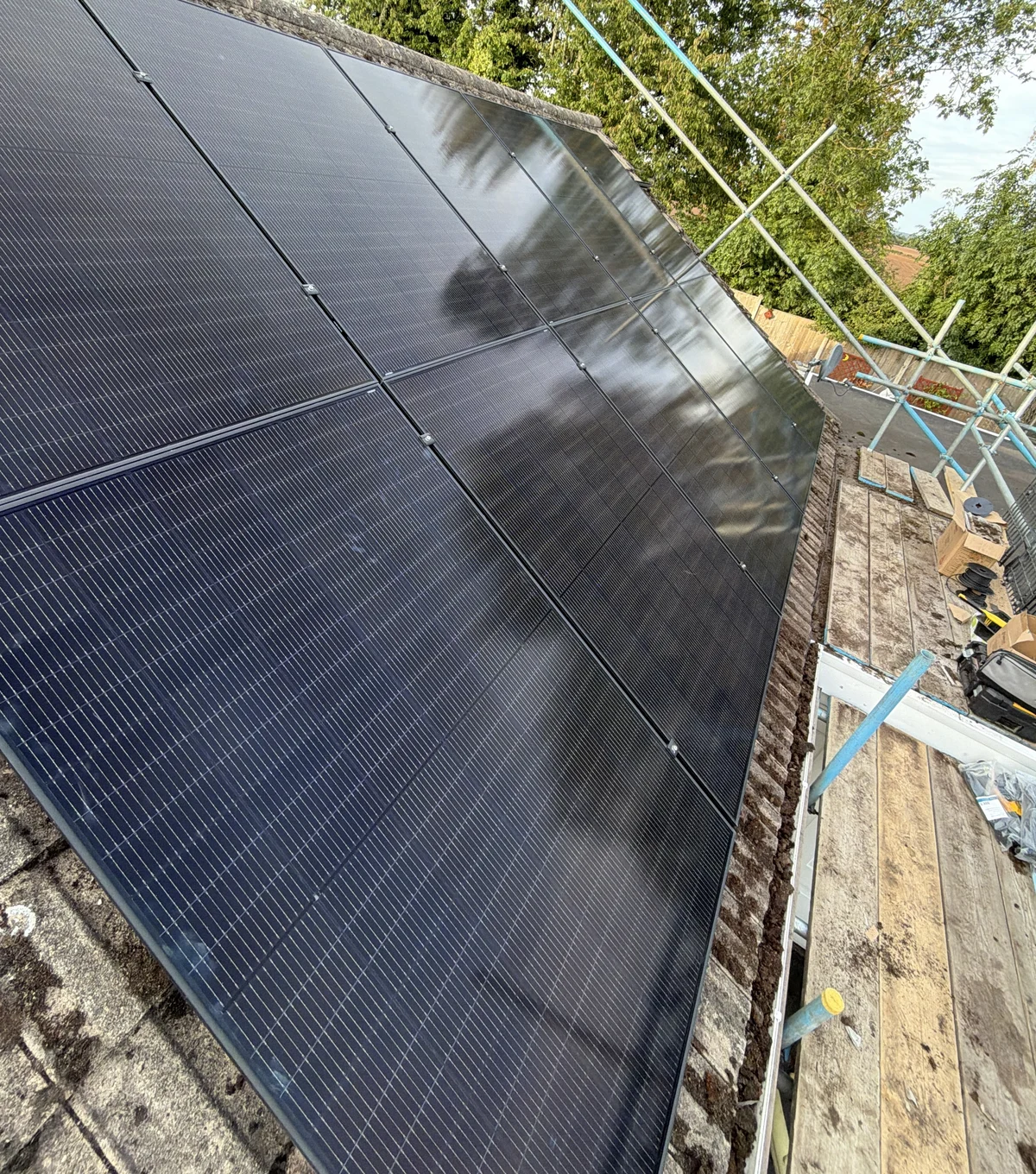 Solar PV panels on a tiled roof with scaffolding alongside